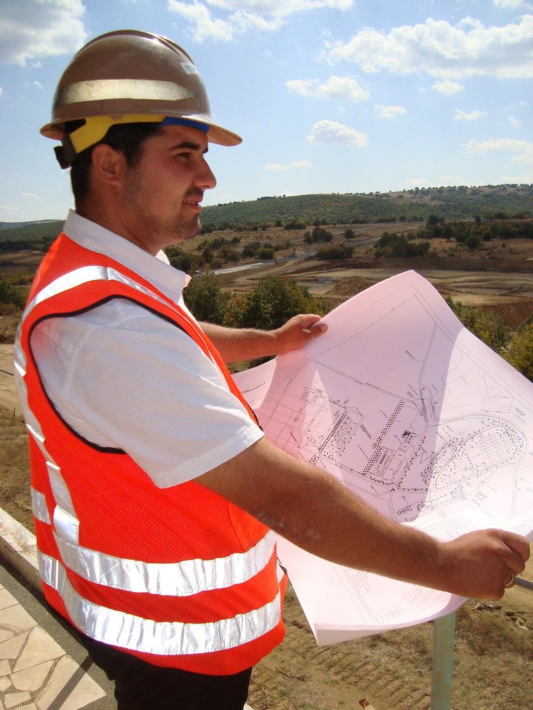 Engineer reviewing technical drawings on site